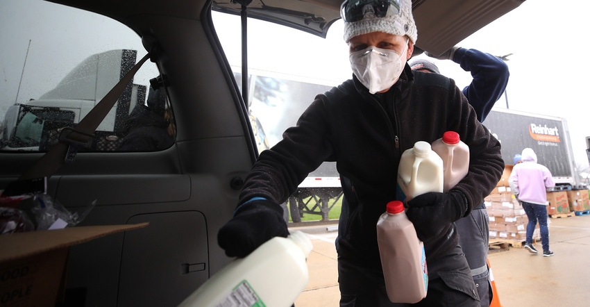 Woman carrying half gallons of milk Woman carrying half gallons of milk