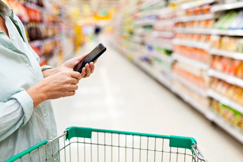 woman grocery shopping while on mobile phone