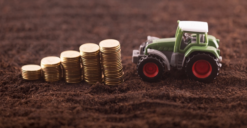 miniature tractor with trail of stacked coins on soil