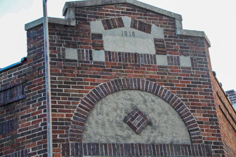 The facade of a U.S. Post Office building constructed of brick with 1918 etched into it