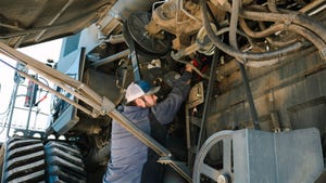 A mechanic working on a combine