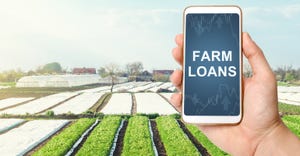 hand holding smartphone with the words Farm Loans on the screen