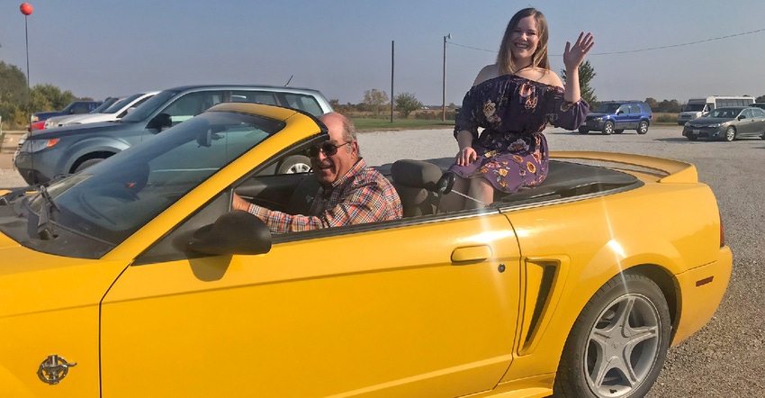 Jim Lock and Jenna Spangler in yellow Mustang convertible