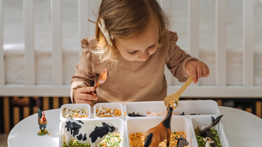 Preschool girl with sensory play bin