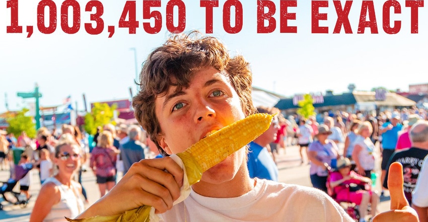 man eating corn on the cob with people in background