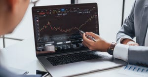 Market analyst sharing laptop