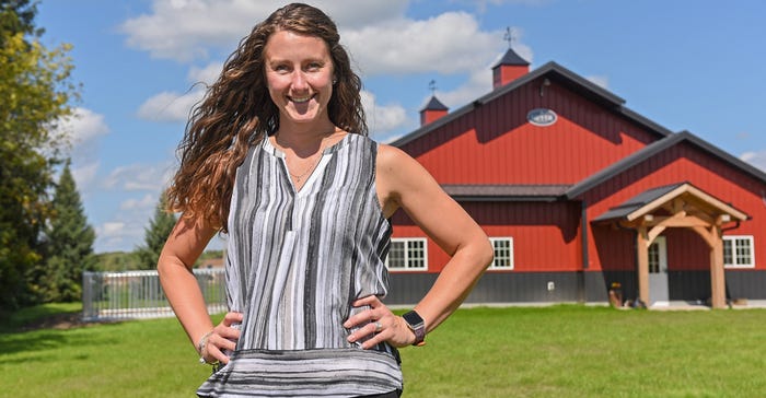 Lisa Kopp posing with hands on hips with a red barn in the background
