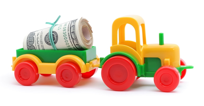Colorful toy tractor with money in wagon