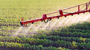 Spraying soybean field with herbicide