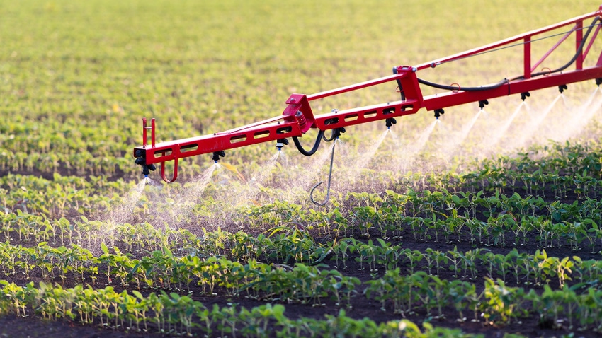 Spraying soybean field with herbicide