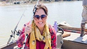 A woman in a boat holding a fishing rod