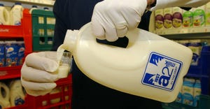 A grocery store employee pours samples of A2 milk