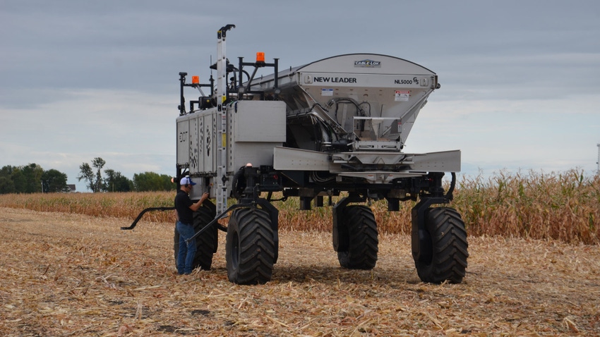 A technician adjusts the controls on Dot, an autonomous fertilizer spreader 