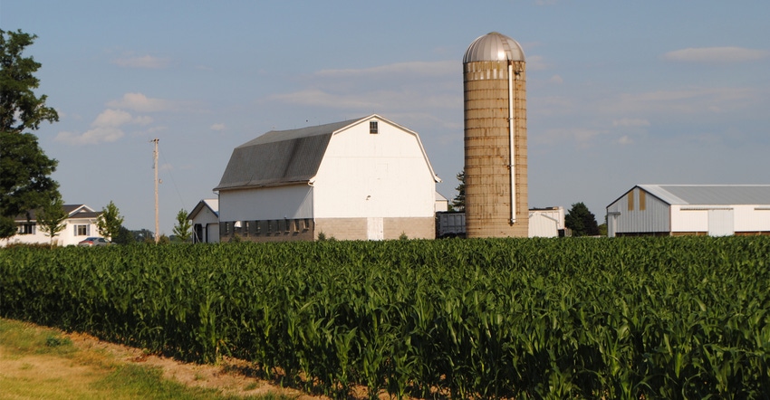 barn and silo with corn field in foreground