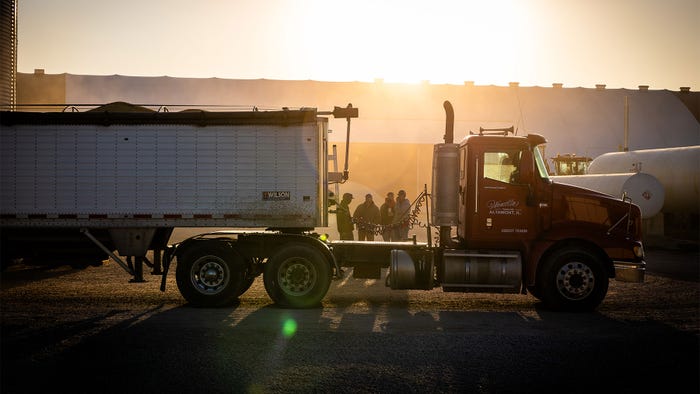 Farmers gather behind a semi truck during a sunrise Farmers gather behind a semi truck during a sunrise