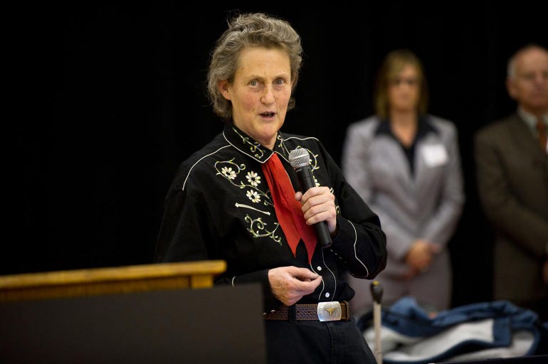 Temple Grandin speaking into a microphone at a public speaking event