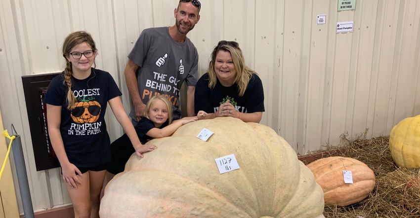 Calvin Beeson, his wife Paige, and their daughters, Olivia and Hadley, pose with “Trashcan” the 1,127.2-pound, Kansas-rec