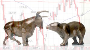 Bear and bull figurines in front of market chart.