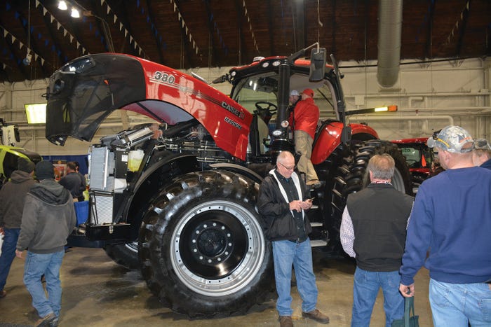 Visitors at the New York Farm Show climb into equipment inside the Exposition Center