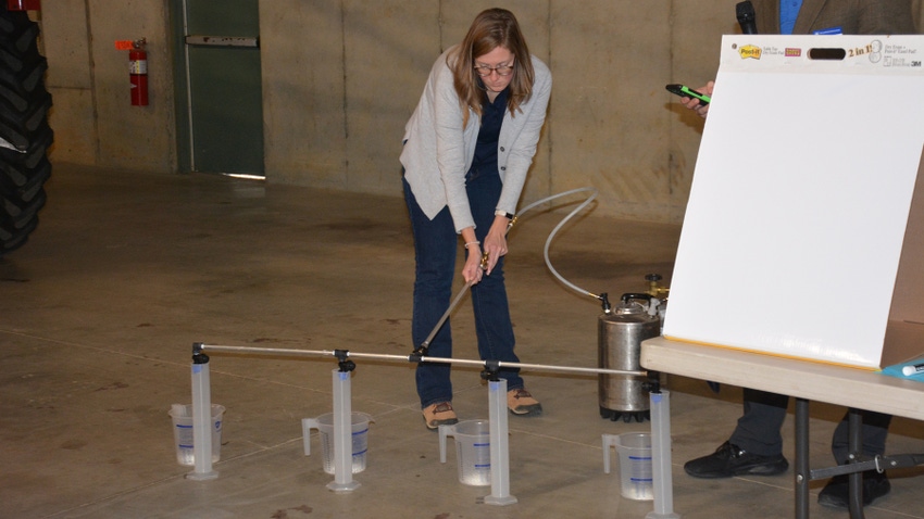 Kara Pittman demonstrates how to measure nozzle output during a crops conference in Lebanon, Pa.