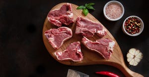 Raw fresh Lamb Meat ribs and seasonings on wooden cutting board.