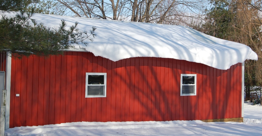 red pole barn with snow on roof