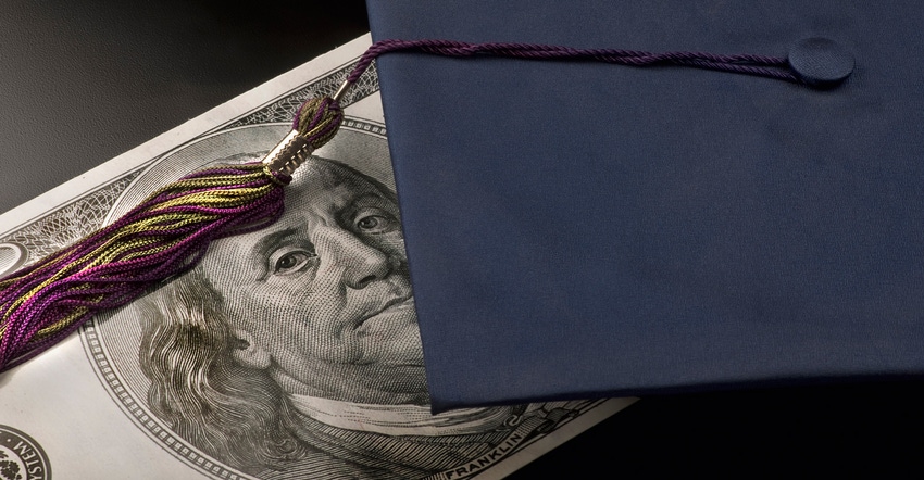 graduation cap with hundred dollar bill beneath it