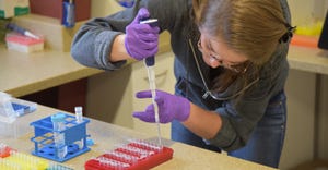 a girl putting liquid in test tubes
