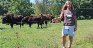 Carie Starr standing in field with bison