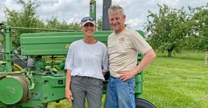 Kristi and Tim Schulz standing in front of vintage tractor