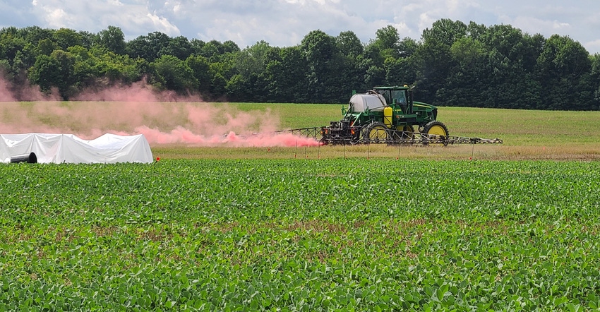 tractor applying dicamba to soybean field