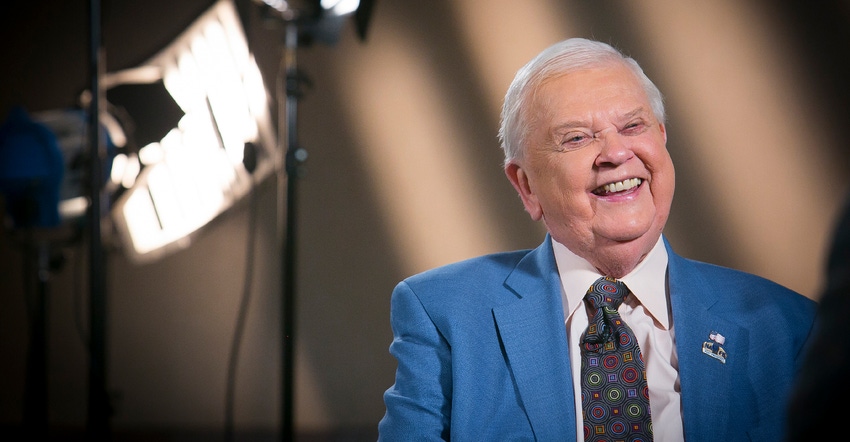 Orion Samuelson sits in front of lights and backdrop