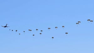 Nebraska Army National Guard paratroopers parachuting down from the sky