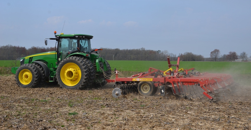 tractor and vertical-tillage tool in field