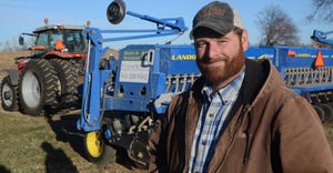 Wade Dooley stands with his grain drill in the background. 