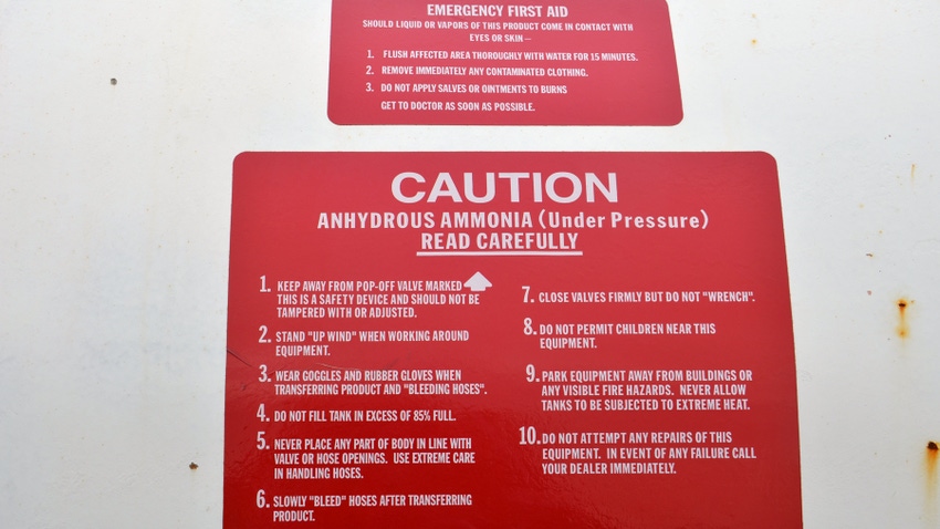 caution and first aid signs placed on anhydrous ammonia tank
