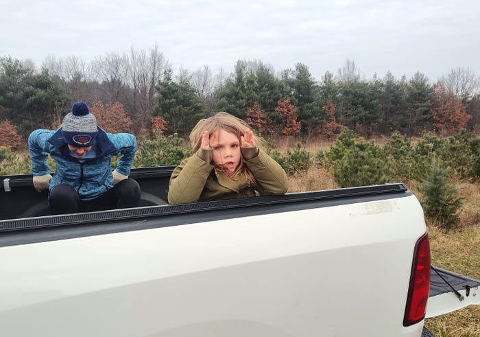 Young girl in bed of pickup truck at a tree farm