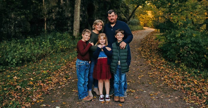 Nathan and Jennifer Brown standing with their children on rural road Nathan and Jennifer Brown standing with their children on rural road