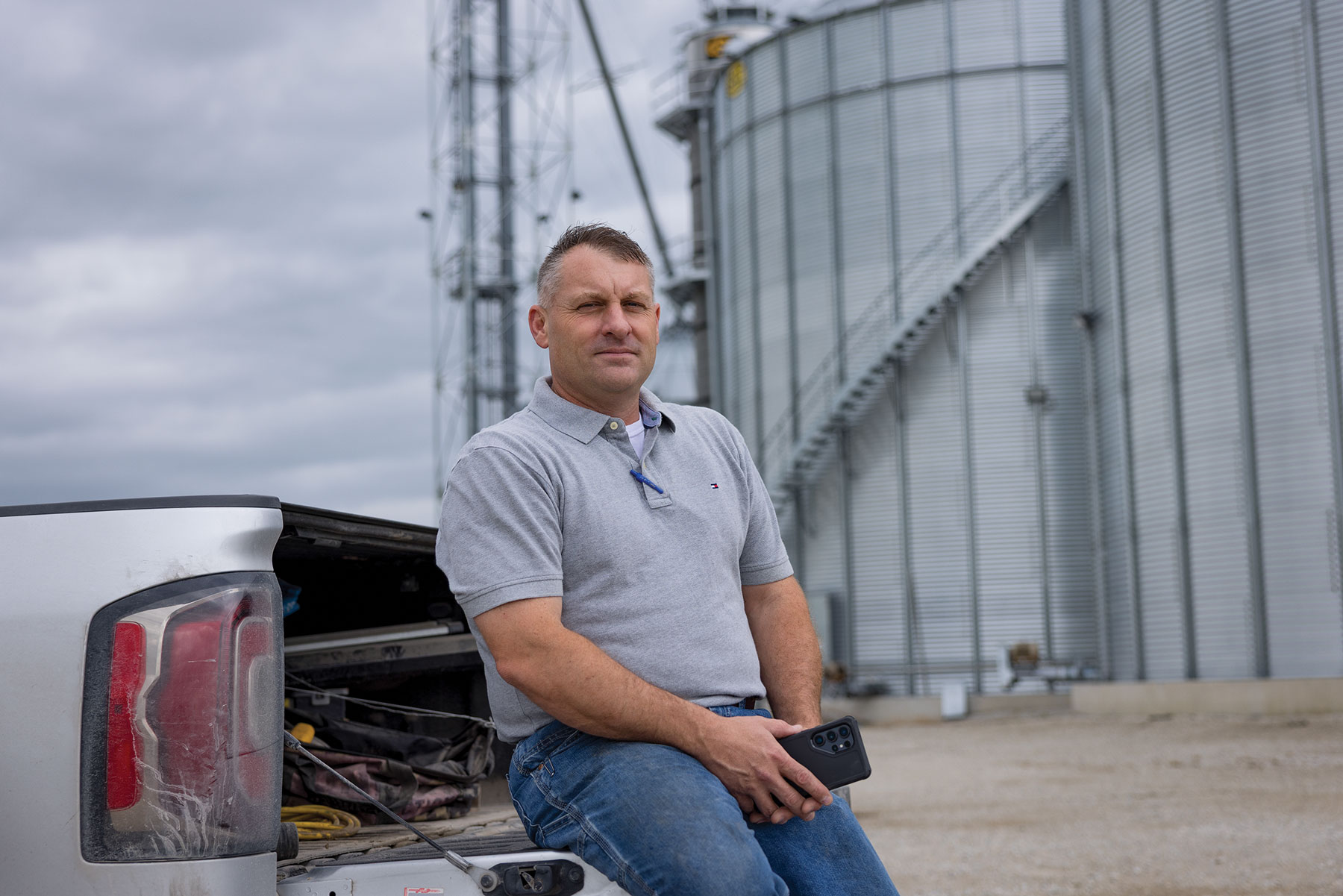 farmer Vince Reincke leans on the tailgate of a pickup truck
