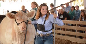 girl showing a beef cow