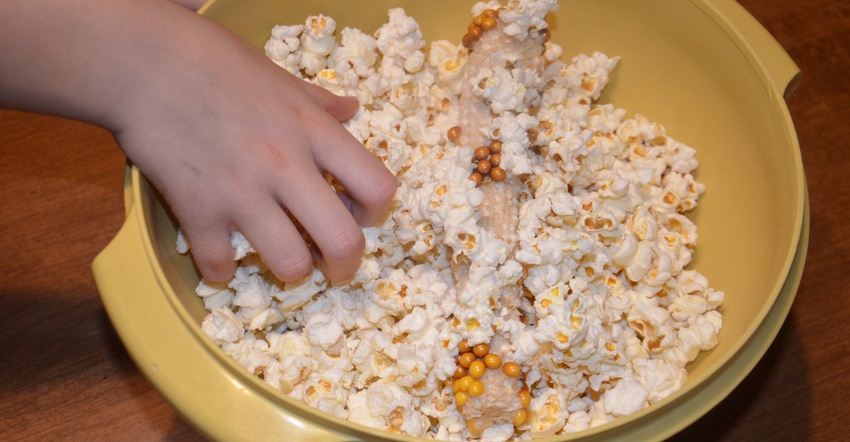 hand reaching into bowl of popcorn