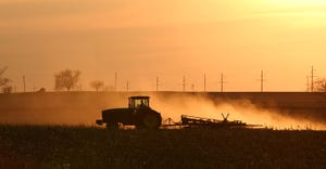tractor tilling an Illinois field at sunset
