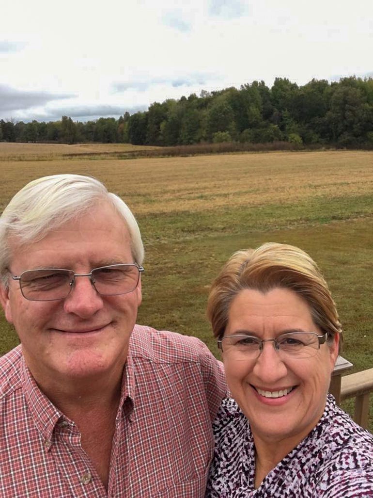 Gene and Pam Rowland taking a selfie with a field in a background