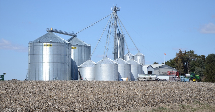 grain bins with dead corn field in foreground