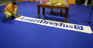 Hector Rainey from Louis Dreyfus rolls a banner out in front of the desk where they will sign an agreement for trade with the