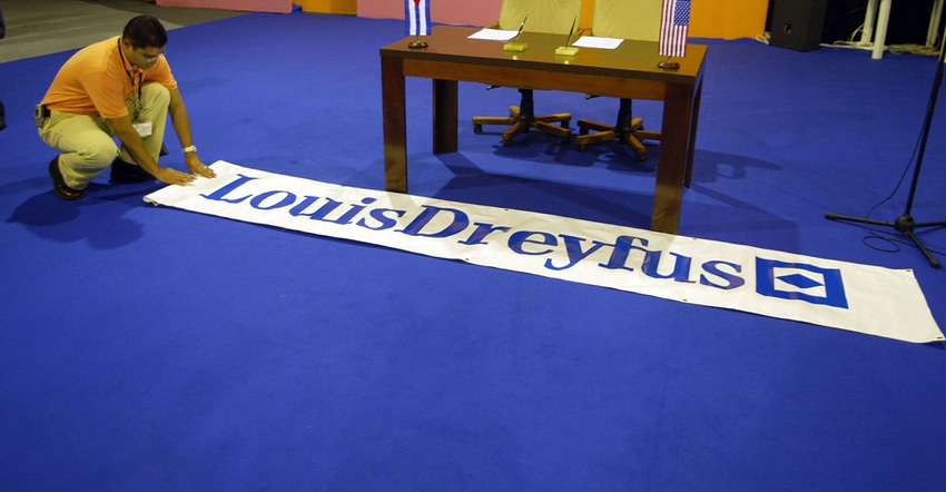 Hector Rainey from Louis Dreyfus rolls a banner out in front of the desk where they will sign an agreement for trade with the