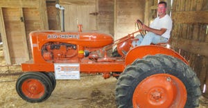 A man sitting on a 1941 Allis-Chalmers WC tractor in a barn