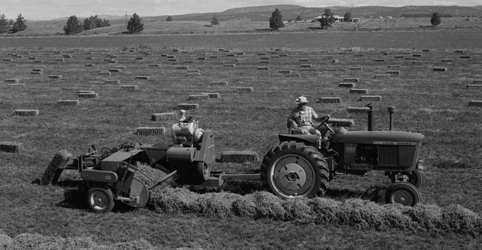 black and white photo of gasoline engine-powered hay baler
