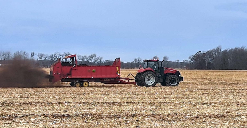 Tractor pulling manure spreader 