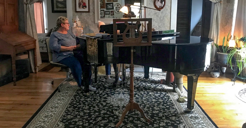 Paula Helle in her music room with student at piano